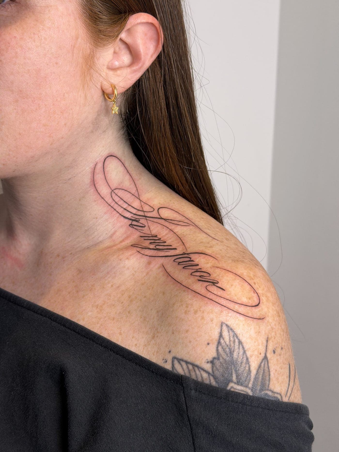 Tatuaje fine line — Lettering en la clavícula